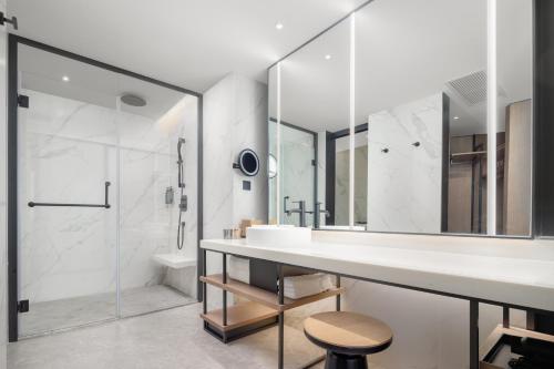 a white bathroom with a sink and a shower at Sheraton Chengdu Lido Hotel in Chengdu