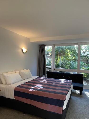 a bedroom with a bed and a large window at The Devereux Boutique Hotel in Auckland