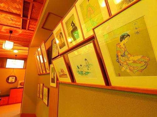 a hallway with a bunch of pictures on a wall at Oyado Yamashita in Kanazawa