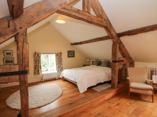 een slaapkamer met een groot bed en houten balken bij Old Coach House in Shrawardine