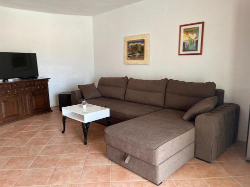 a living room with a couch and a table at Apartment Željka-25m from beach in Zaglavice
