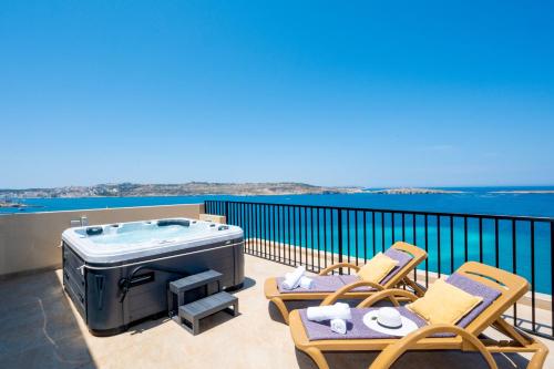 a patio with chairs and a hot tub on a balcony at Islet Promenade Seafront Penthouse with breathtaking seaviews and private hot tub on the large terrace by Getawaysmalta in St. Paul's Bay