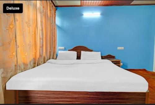 Bett in einem Zimmer mit einer weißen Matratze in der Unterkunft Nishat lake view resort in Srinagar
