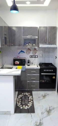 eine Küche mit Edelstahlschränken und einem Herd in der Unterkunft Seckebe immo et Business STUDIO DAKAR Suite 4 in Dakar