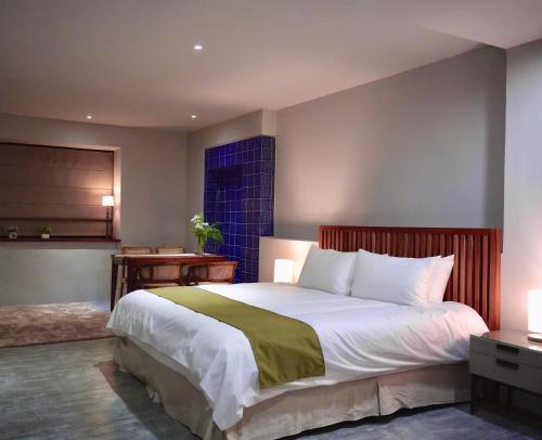 um quarto com uma cama grande e uma janela em The MSUG Hotel em Tainan