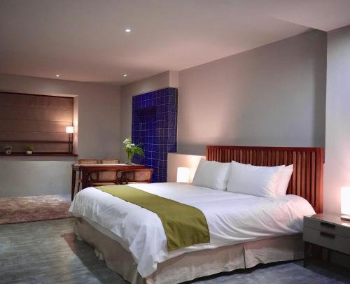 una camera da letto con un letto grande e una finestra di The MSUG Hotel a Tainan
