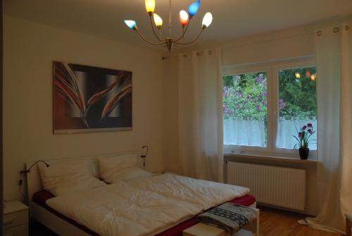 a bedroom with a bed and a window and a chandelier at Barock Hengst Hof in Niederhaverbeck