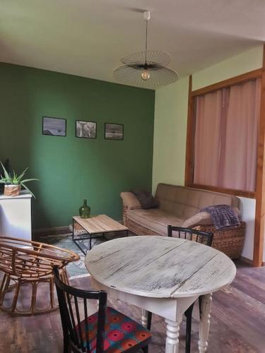 sala de estar con mesa, sillas y sofá en appartement, en Limeyrat