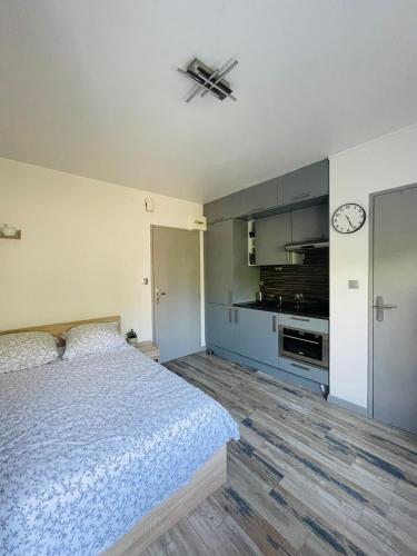 une chambre avec un lit et une horloge au mur dans l'établissement DnN - Stylish Studio - free WiFi, Netflix and parking - min away to Basel and Airport - dishwasher, washing machine, à Saint-Louis
