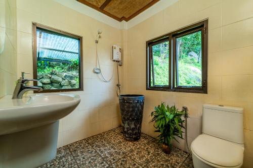 łazienka z umywalką, toaletą i oknem w obiekcie White Azure Villa Two w mieście Than Sadet Beach