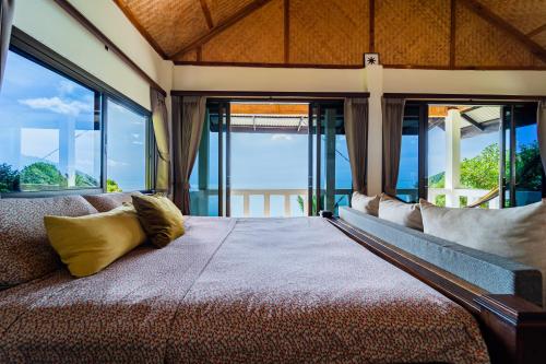 1 dormitorio con 1 cama grande y ventanas grandes en White Azure Villa Two, en Than Sadet Beach