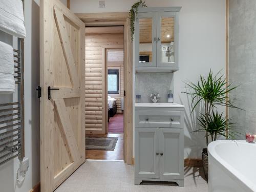 a bathroom with a door leading to a bedroom at Alpaca Lodge in Barkston