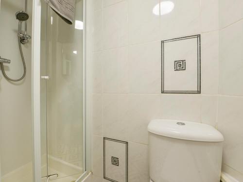 a white bathroom with a toilet and a shower at SoundView in Plymouth