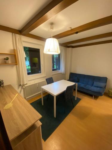 a living room with a table and a blue couch at NOCK - Zentrum Studio in Bad Kleinkirchheim