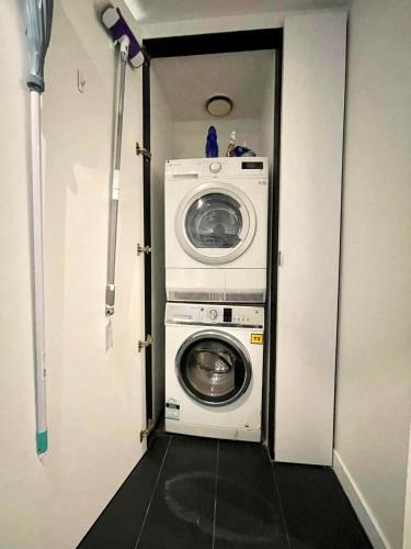a washer and dryer in a small room at ‘Sunrise on Aura’ Apartment with stunning views. in Melbourne