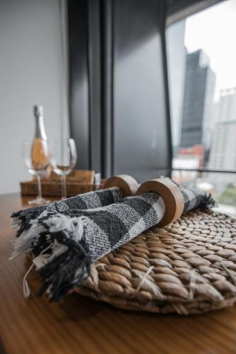 a wicker basket on a wooden table with a window at ‘Sunrise on Aura’ Apartment with stunning views. in Melbourne