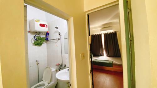 a bathroom with a toilet and a sink and a mirror at Cuccu homestay in Kiến An