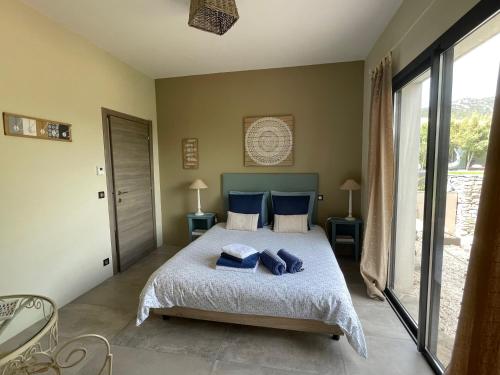 ein Schlafzimmer mit einem Bett mit blauen Kissen darauf in der Unterkunft Le Domaine du Cade - Gîtes d'exception 4 étoiles "Le Lodge du Cade " in Cazevieille