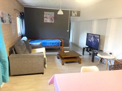 a living room with a couch and a bed at Maison de 2 chambres avec terrasse amenagee et wifi a La Plaine des Cafres in La Plaine des Cafres