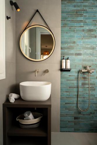 a bathroom with a sink and a mirror at Koumbara Sea View in Ios Chora
