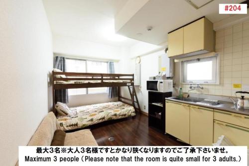 una pequeña cocina con una litera en una habitación en Luxes Hiroshima2030 ラクセス ヒロシマ2030 en Hiroshima