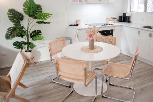 a kitchen with a white table and chairs at Malie - By The Sea in Torquay