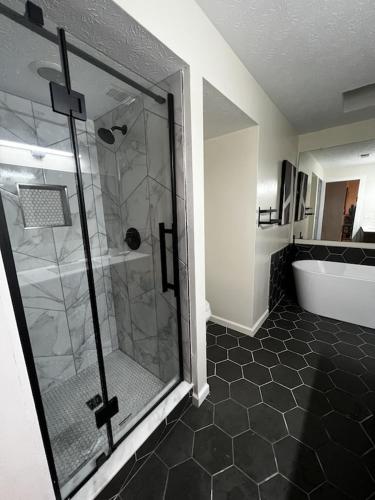 uma casa de banho com um chuveiro e uma banheira em Spacious & Cozy - Close to Fort Moore - Pool Table em Columbus