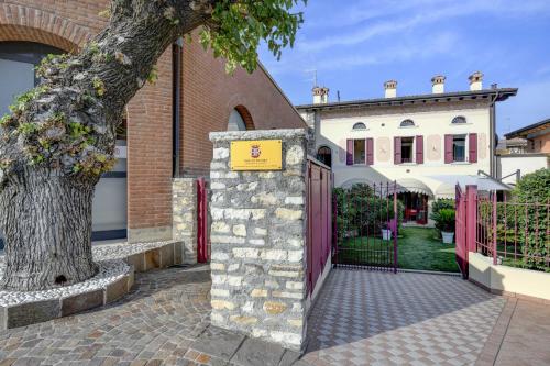 Una puerta a una casa con un cartel. en Barchi Resort - Apartments & Suites, en San Felice del Benaco