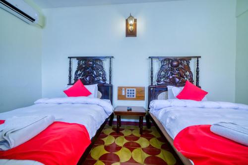 two beds in a room with red and white pillows at HOTEL WINDSOR CASTLE in Salem