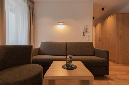 a living room with a couch and a coffee table at Berghotel Rasis in Galtür