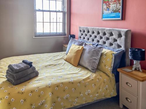 a bedroom with a bed with a yellow comforter at The Lookout in Scarborough