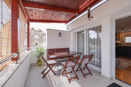 a balcony with a table and chairs on it at Apartman Fortuna in Zadar