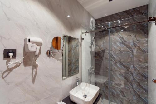 uma casa de banho com um chuveiro e um lavatório. em Hotel Marwa Tashkent Pool&Spa em Tashkent