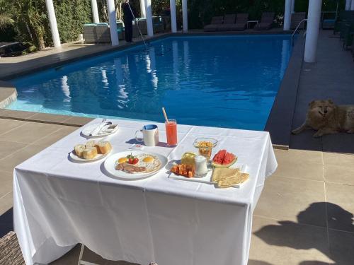 a table with food on it next to a swimming pool at Ikopa Hôtel Madagascar in Antananarivo