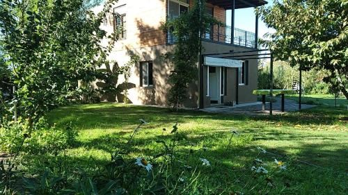 a house with a grassy yard with a building at Chacras casa Armonia in Chacras de Coria