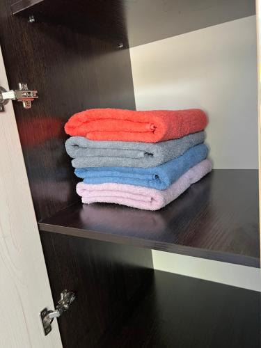a stack of towels sitting on a shelf in a bathroom at Luxe-kvartira in Balqash