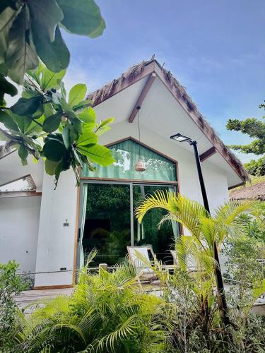 a white house with a window and some plants at Crystal 7 in Haad Tian