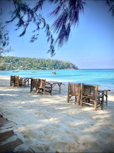 a row of tables and chairs on the beach at Crystal 7 in Haad Tian