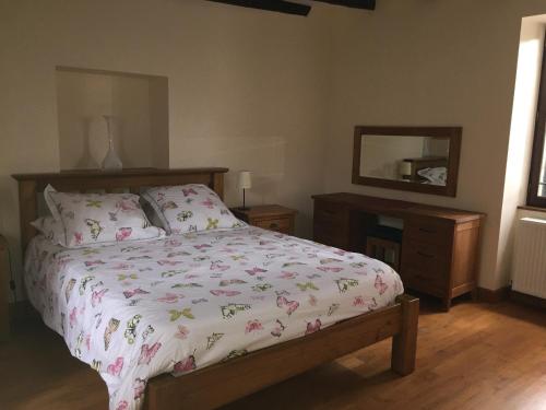a bedroom with a bed and a dresser and a mirror at Cottage de La Mothe in Marnac