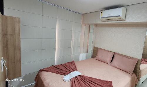 um pequeno quarto com uma cama e ar condicionado em Beira Mar Fortaleza Landscape Luxo em Fortaleza