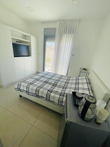 een slaapkamer met een bed, een tv en een raam bij דירת סטודיו באילת in Eilat