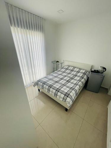 een bed in een witte kamer met een raam bij דירת סטודיו באילת in Eilat