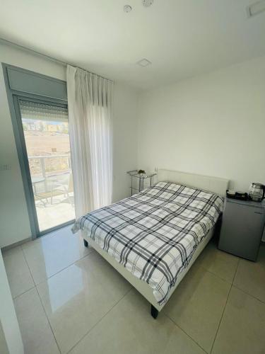 een slaapkamer met een bed en een groot raam bij דירת סטודיו באילת in Eilat