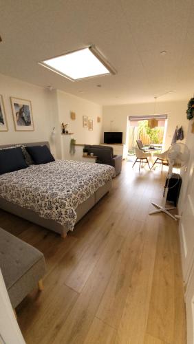 a bedroom with a bed and a living room at Studio Sturjalland in Sirjansland