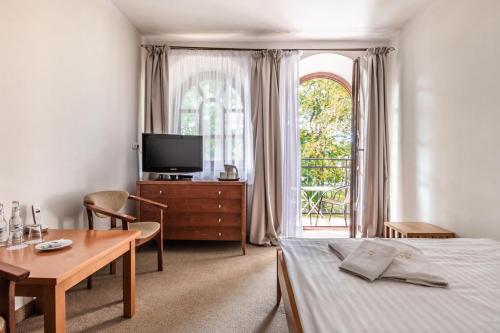 a bedroom with a bed and a table and a tv at Willa Bór in Zakopane