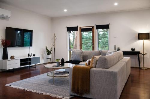 a living room with a couch and a table at Minni Gums- a perfect romantic getaway in Daylesford