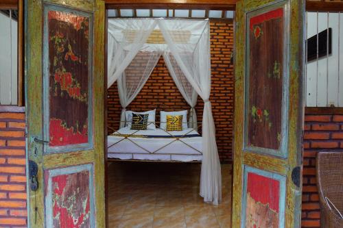 a bedroom with a bed with a canopy at Hotel O Holy HomestayNearWisata Kopi Desa Tamansari in Banyuwangi