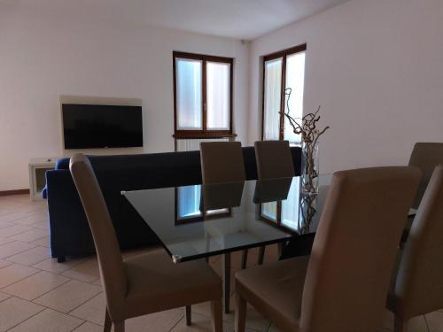 a dining room with a glass table and chairs at Le Betulle Affittacamere in Sona