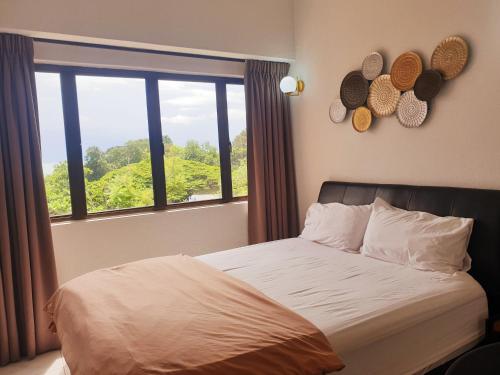 a bedroom with a bed and a large window at Sri Sayang by Coral Holiday Resort in Batu Ferringhi