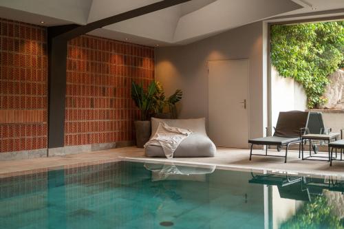 a swimming pool with a table and chairs next to a house at Hotel Pollinger in Merano